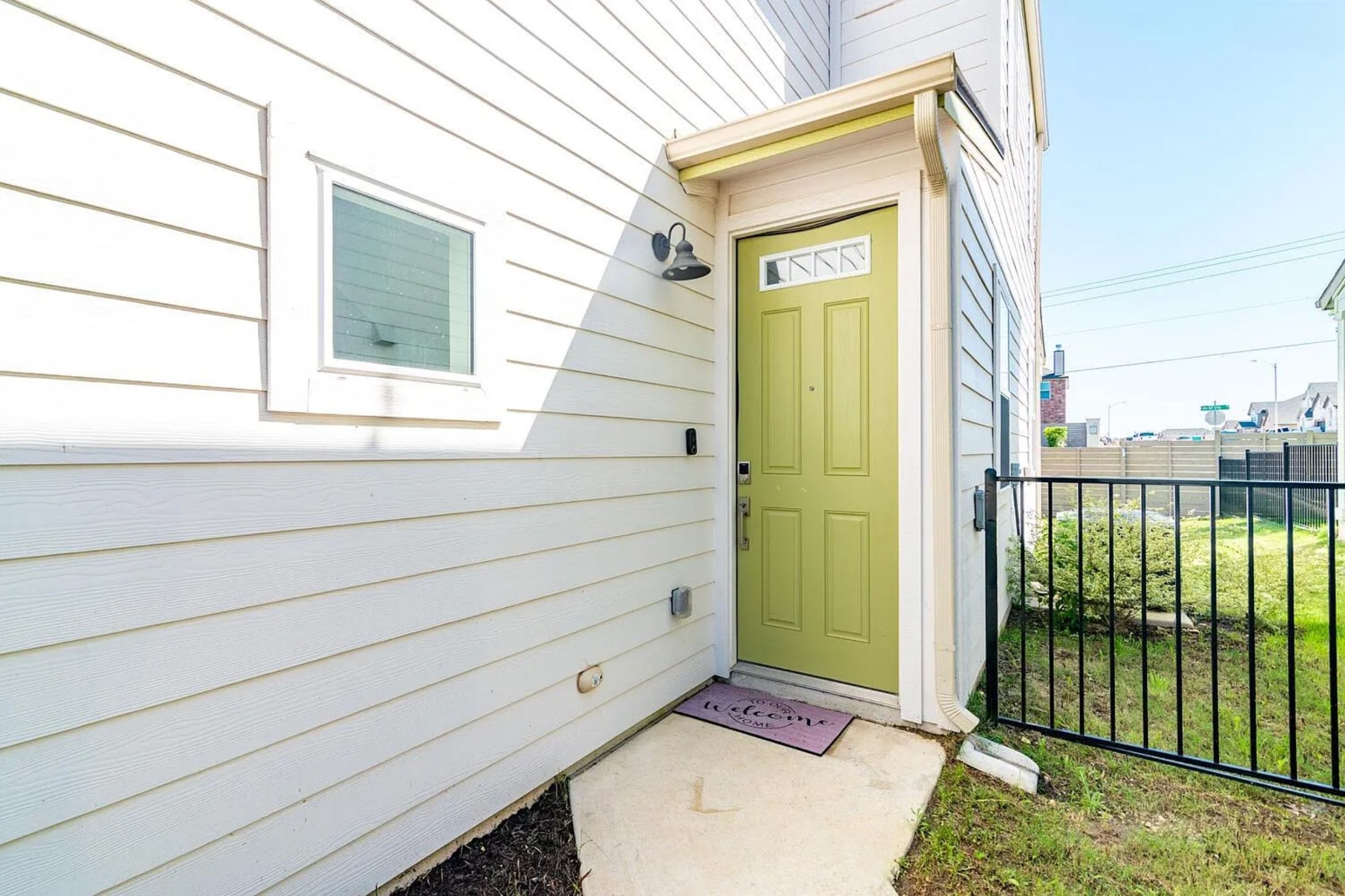 7501 Travertine Spring Drive Austin, TX 78744 - Photo 3 of 28 Light green paneled front door with upper transom window and brass-toned hardware