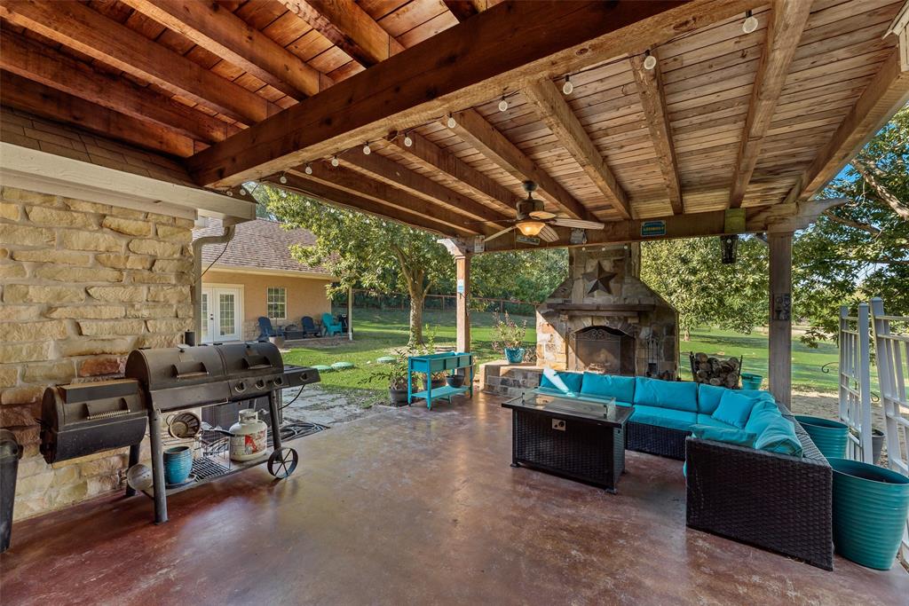 82 Trail Ridge Drive Melissa, TX 75454 - Photo 24 of 29 Patio features stone fireplace, ample seating space, and room for grilling or adding an outdoor kitchen