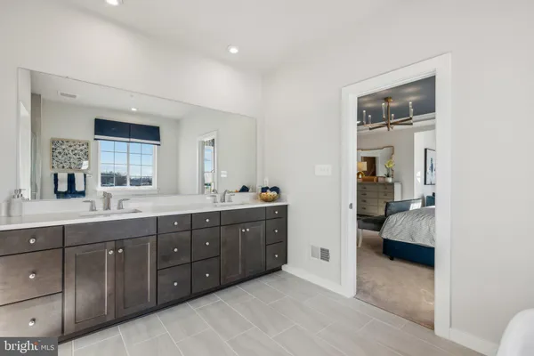 a spacious bathroom with a double vanity sink and a mirror