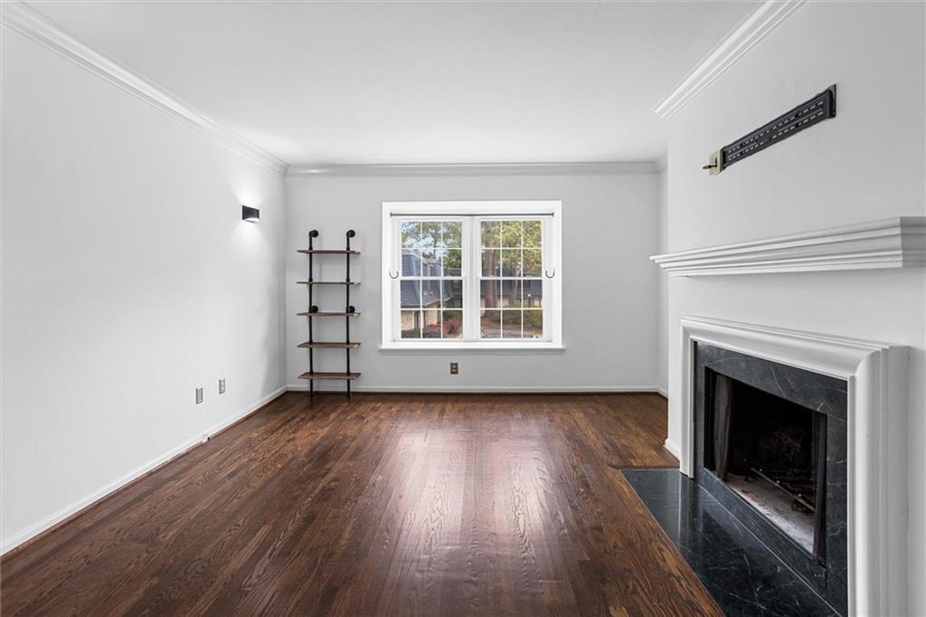 144 Woodmere Square Northwest Atlanta, GA 30327 - Photo 17 of 39 an empty room with wooden floor fireplace and windows