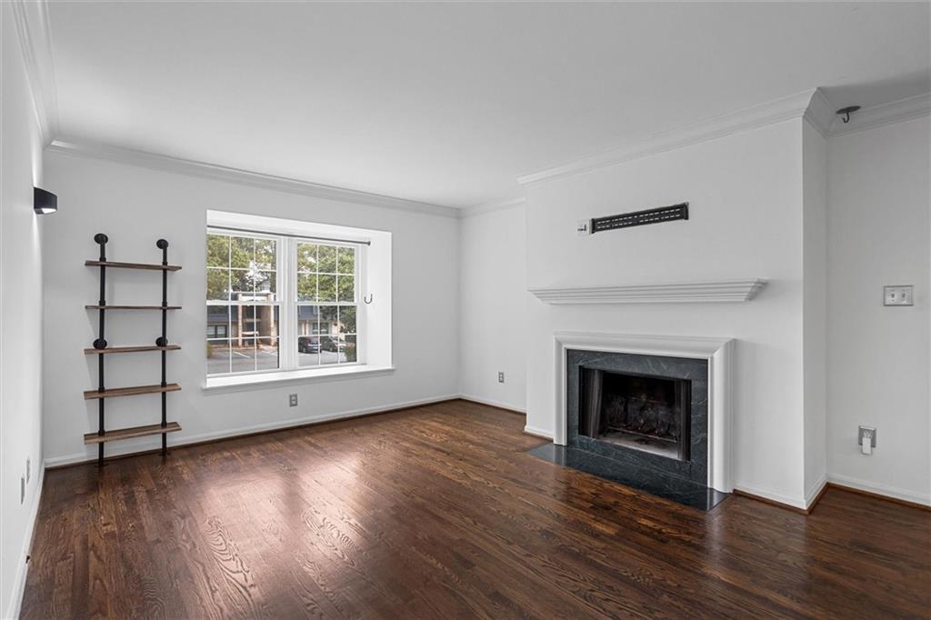 144 Woodmere Square Northwest Atlanta, GA 30327 - Photo 18 of 39 a view of an empty room with wooden floor fireplace and a window