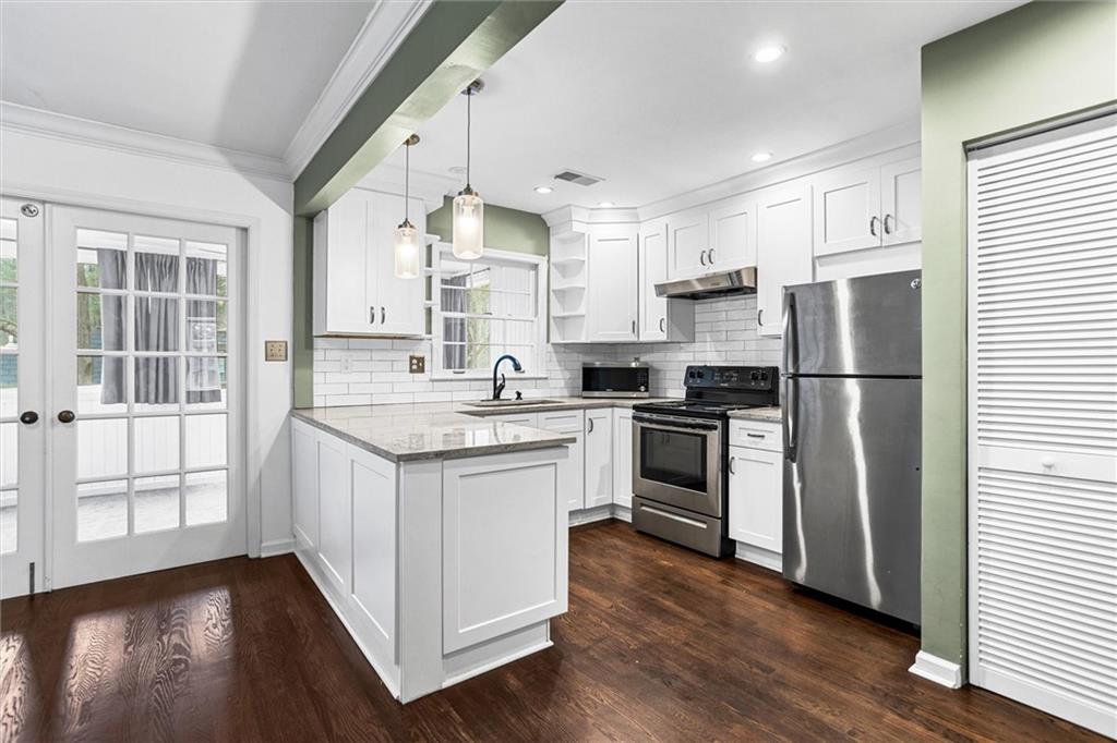 144 Woodmere Square Northwest Atlanta, GA 30327 - Photo 2 of 39 a kitchen with stainless steel appliances granite countertop a refrigerator a sink dishwasher a stove and white cabinets with wooden floor