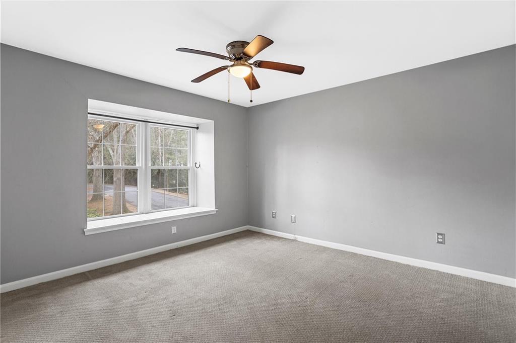 144 Woodmere Square Northwest Atlanta, GA 30327 - Photo 34 of 39 an empty room with chandelier fan and windows