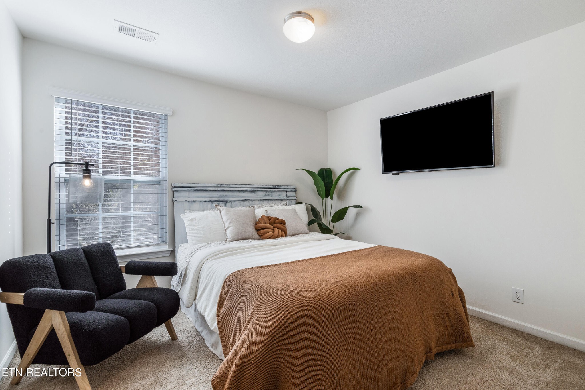 7200 Ponds Inlet Lane Powell, TN 37849 - Photo 21 of 38 a bedroom with a bed a flat screen tv and a couch