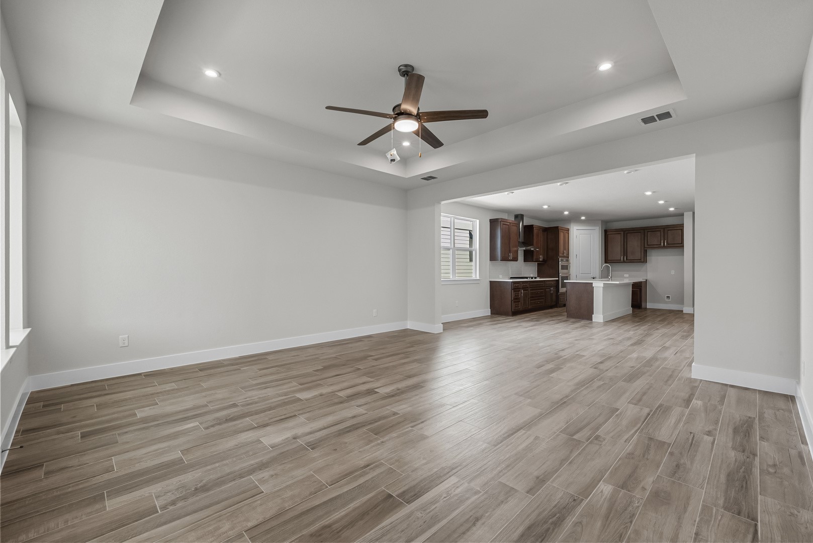 674 Iron Willow Loop Dripping Springs, TX 78620 - Photo 11 of 33 a view of a kitchen with a dishwasher a kitchen island hardwood floor and a ceiling fan
