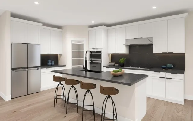 a kitchen with stainless steel appliances a stove a sink a microwave a refrigerator and white cabinets