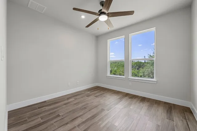 wooden floor in an empty room with a window