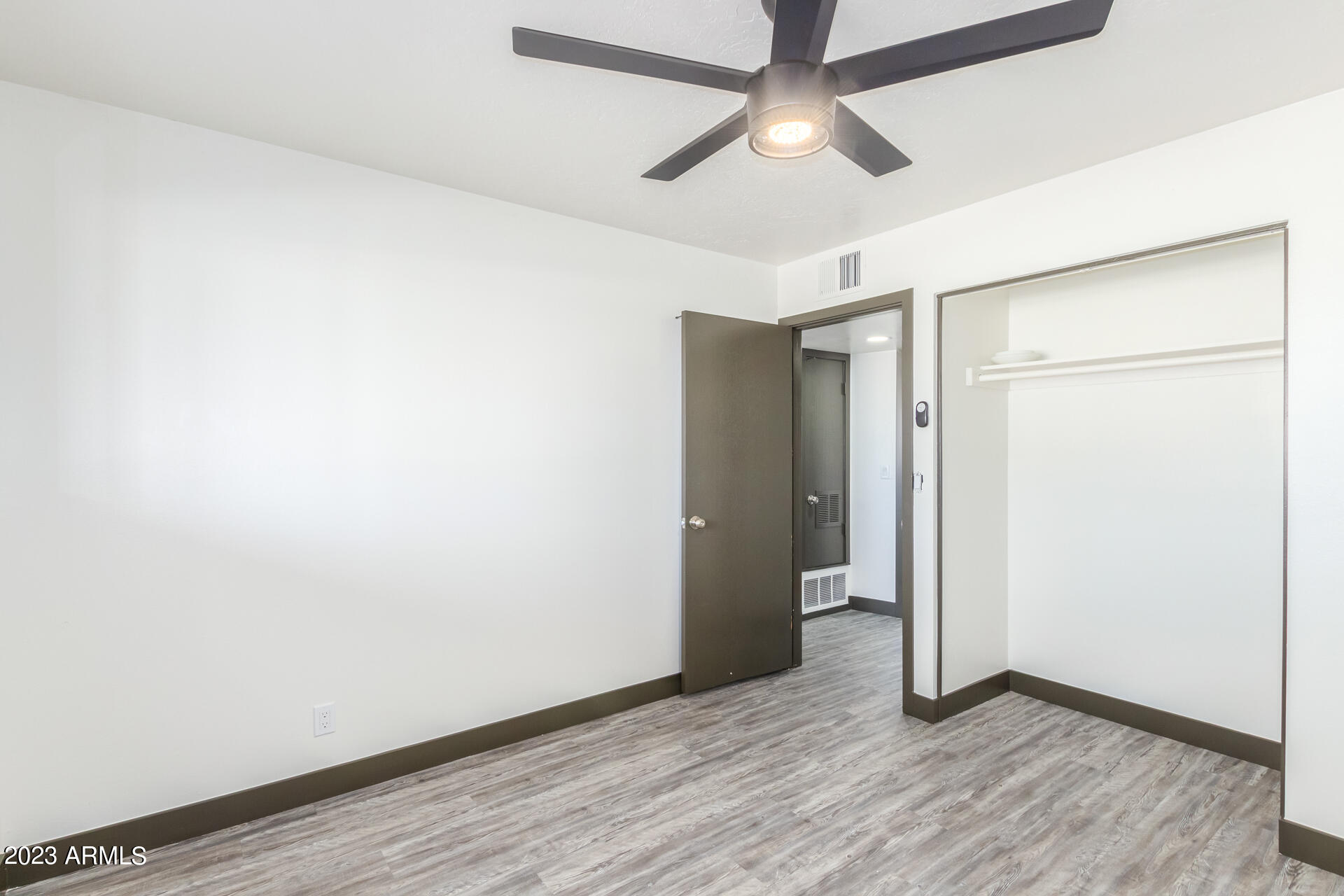 2913 West Charter Oak Road Phoenix, AZ 85029 - Photo 14 of 23 an empty room with wooden floor closet and windows