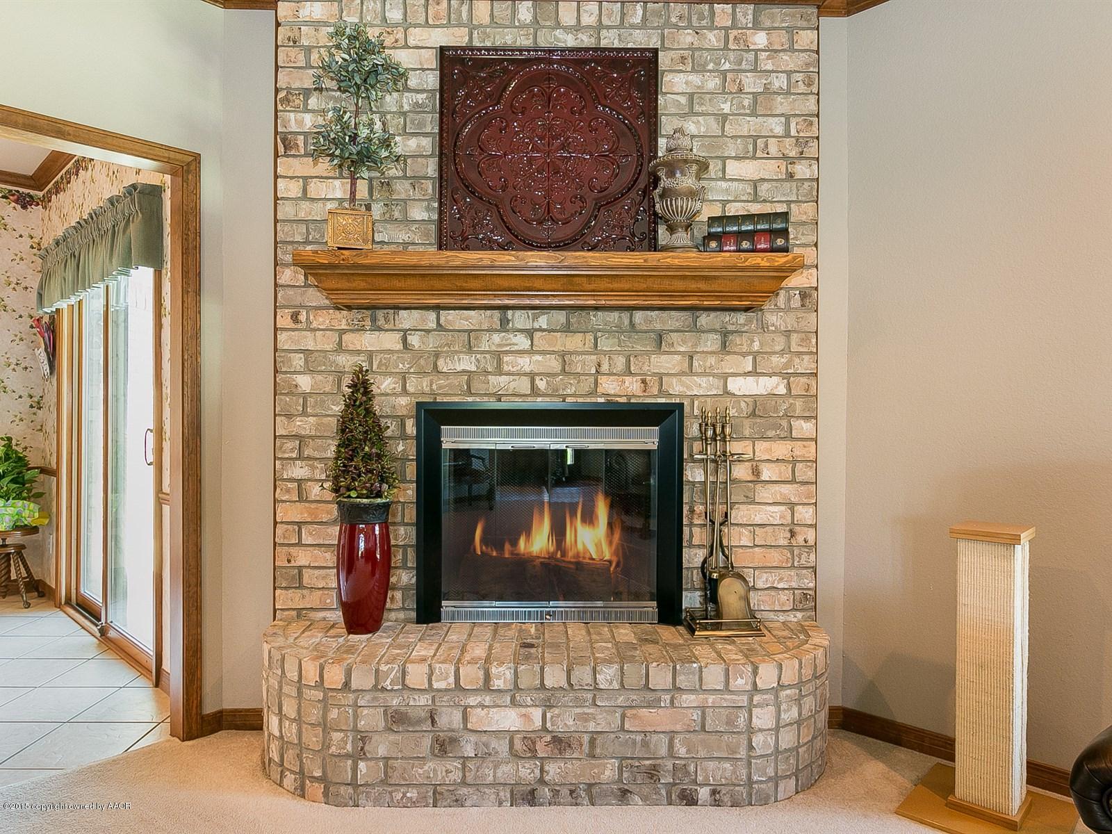 9151 Greyhawk Road Amarillo, TX 79119 - Photo 8 of 31 a fireplace with a wooden floor
