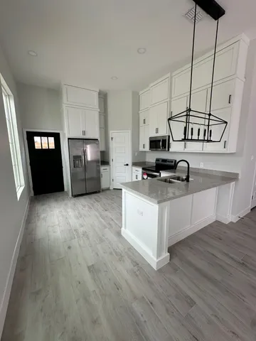 a kitchen with stainless steel appliances a stove top oven and a refrigerator