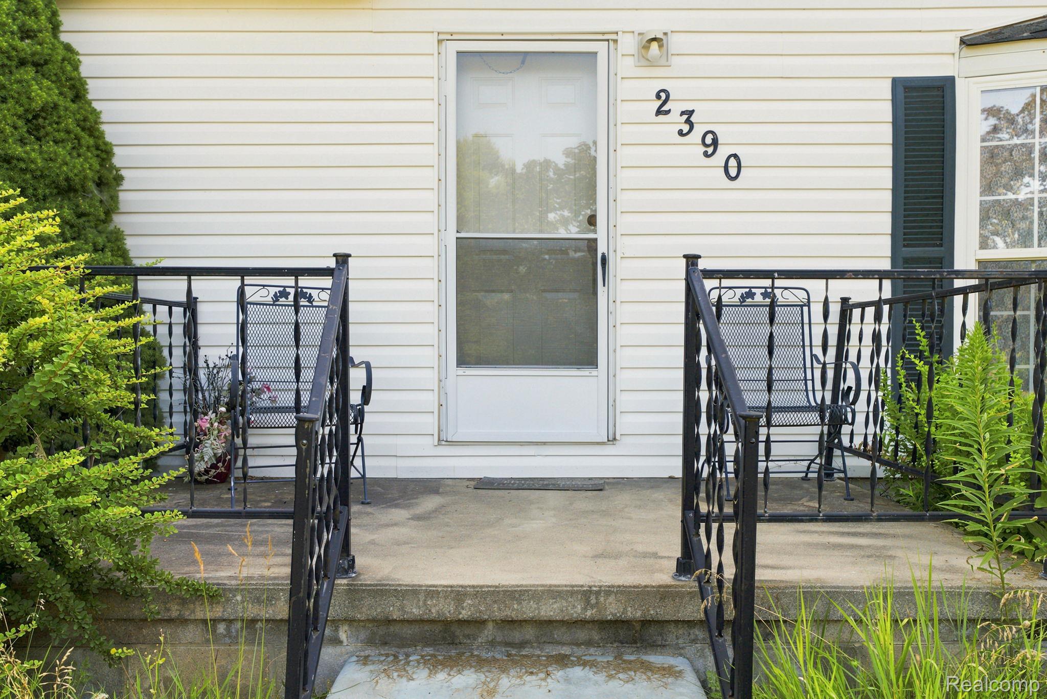 2390 Lakeshore Road Applegate, MI 48401 - Photo 49 of 97 Concrete porch with wrought iron railings, white siding, and dark shutters