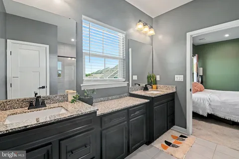 a bathroom with a sink double vanity granite and a mirror