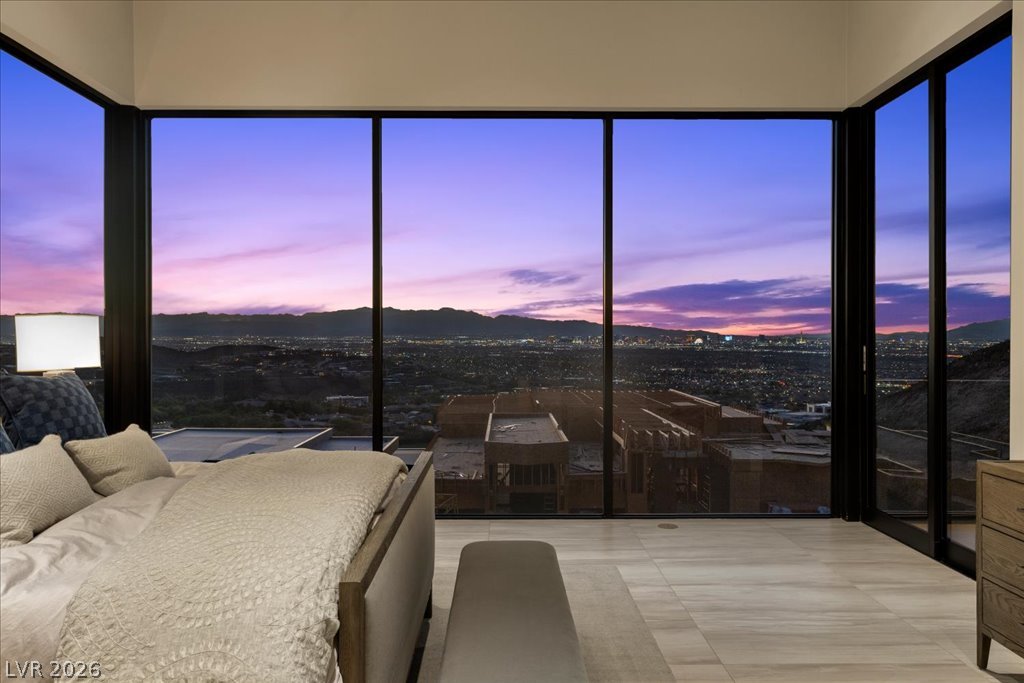 657 Ridgestone Rim Court Henderson, NV 89012 - Photo 31 of 97 Floor-to-ceiling glass walls frame panoramic city and mountain views from this bedroom.