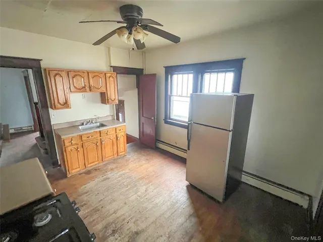 a view of a kitchen with fridge and wooden floor