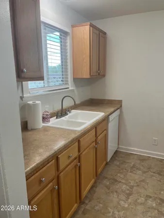 a utility room with sink dryer and cabinets