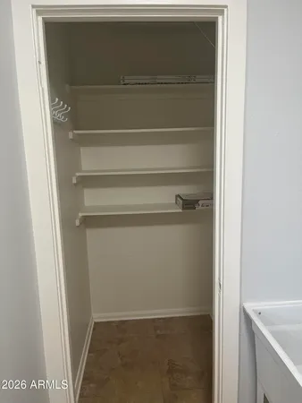a view of walk in closet with empty racks
