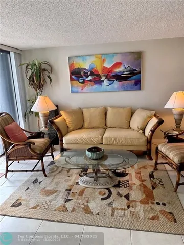 a living room with furniture rug and painting on the wall