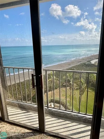 a view of a balcony with floor to ceiling windows with wooden floor