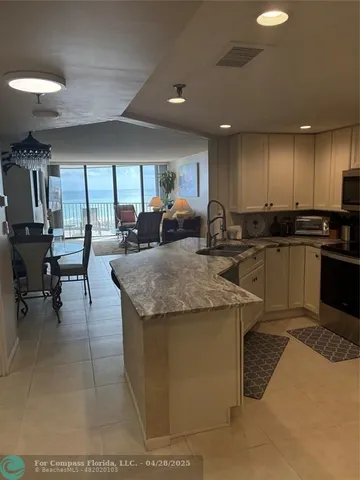 a kitchen with granite countertop a sink a counter top space and stainless steel appliances