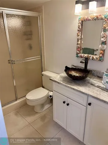 a bathroom with a granite countertop sink mirror vanity and toilet
