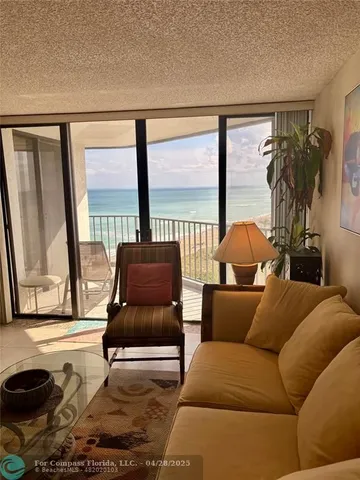 a living room with furniture and a floor to ceiling window