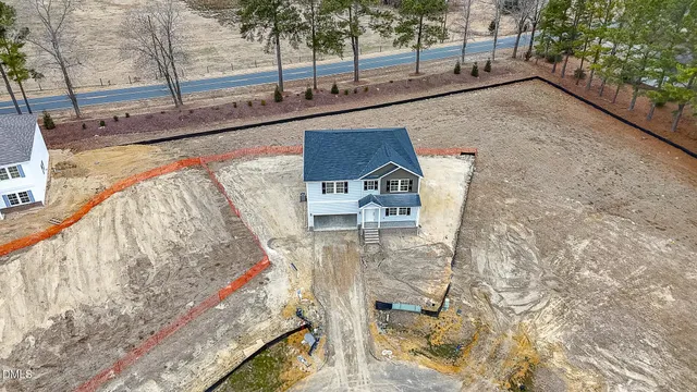 a aerial view of a house with a yard and lake view