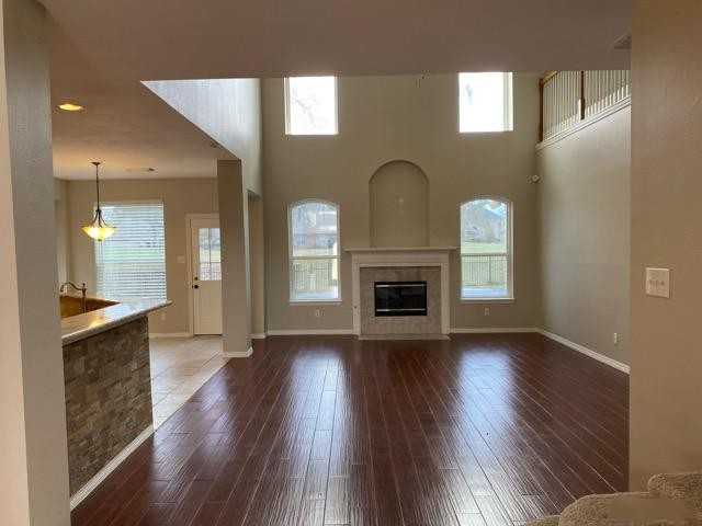 18810 Rusty Anchor Court Humble, TX 77346 - Photo 5 of 26 an empty room with wooden floor a fireplace and windows