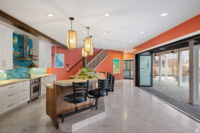 1263 Chapman Court Alpine, UT 84004 - Photo 63 of 83 Dual tone kitchen featuring a breakfast bar area, open shelves, hanging light fixtures, two tone cabinets, and stainless steel oven