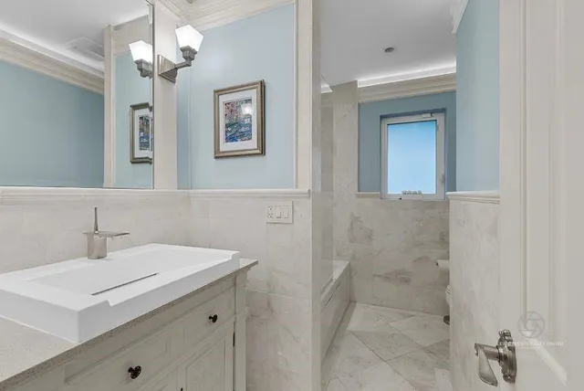 a bathroom with a sink a light fixture and a mirror
