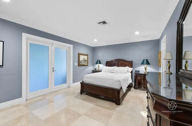 a spacious bedroom with a bed and a flat screen tv