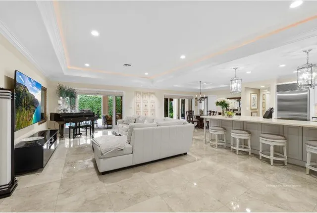 a living room with furniture a table and kitchen view
