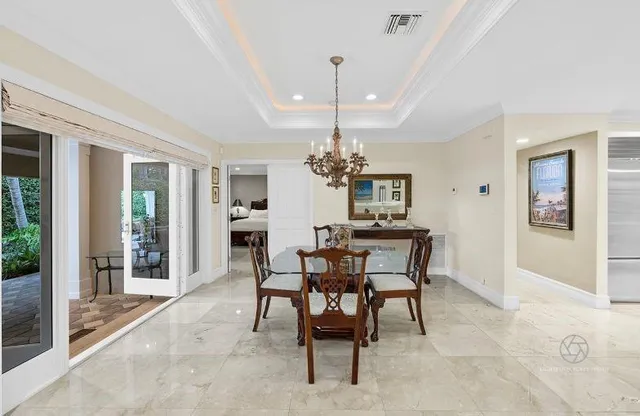a dining room with furniture a chandelier and window