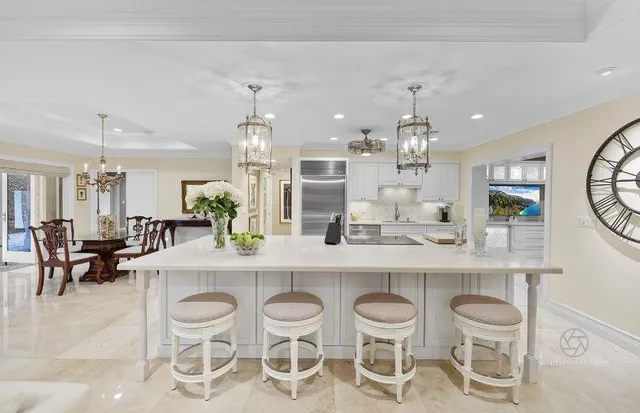 a kitchen with a dining table chairs stainless steel appliances and cabinets