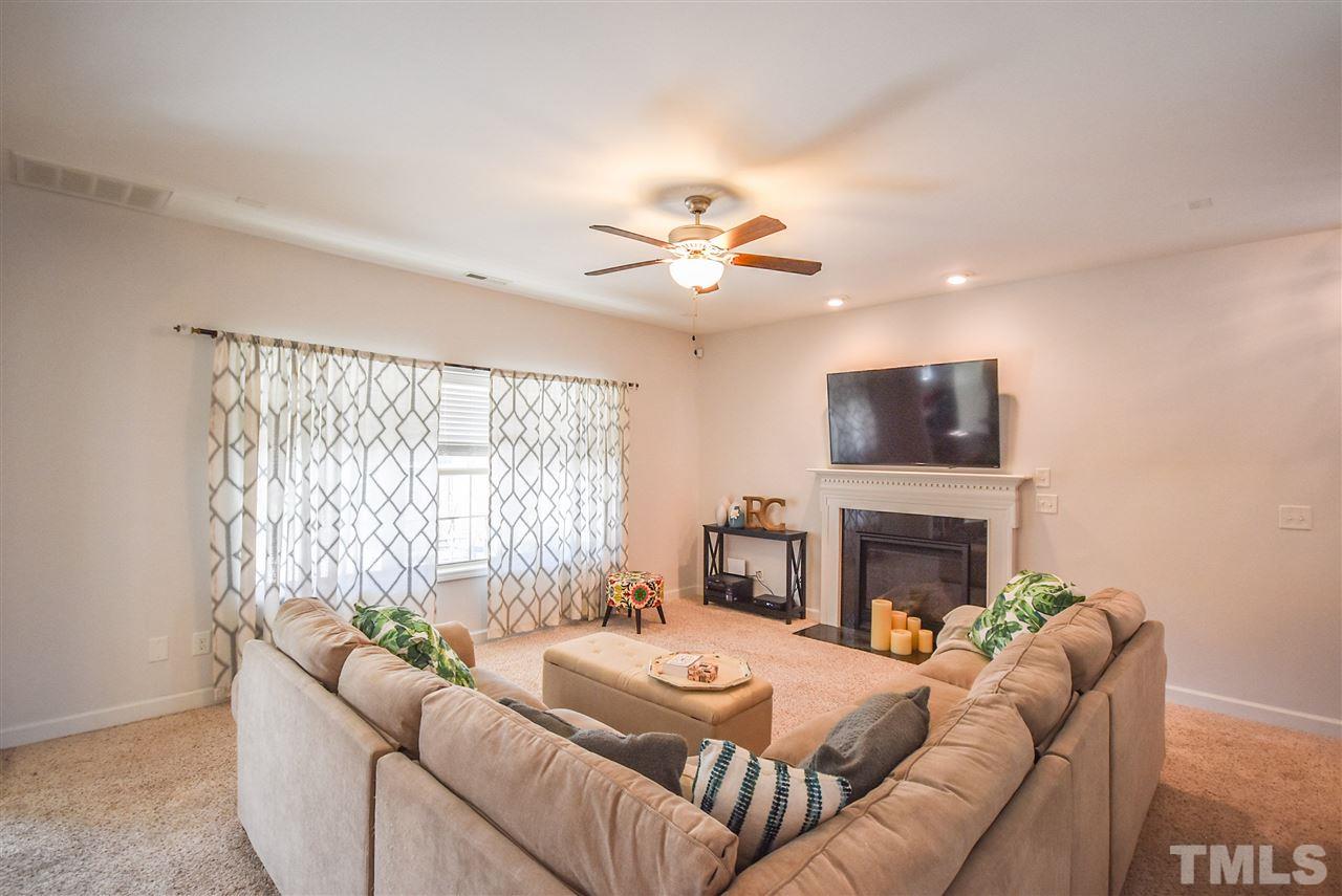 146 Shellbark Drive Spring Lake, NC 28390 - Photo 3 of 25 a living room with furniture a fireplace and a flat screen tv