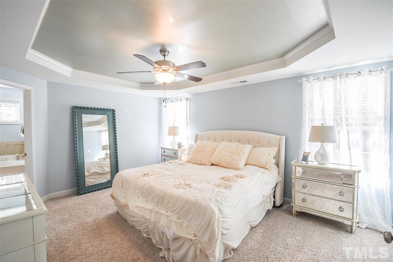 146 Shellbark Drive Spring Lake, NC 28390 - Photo 9 of 25 a bedroom with a large bed and a chandelier