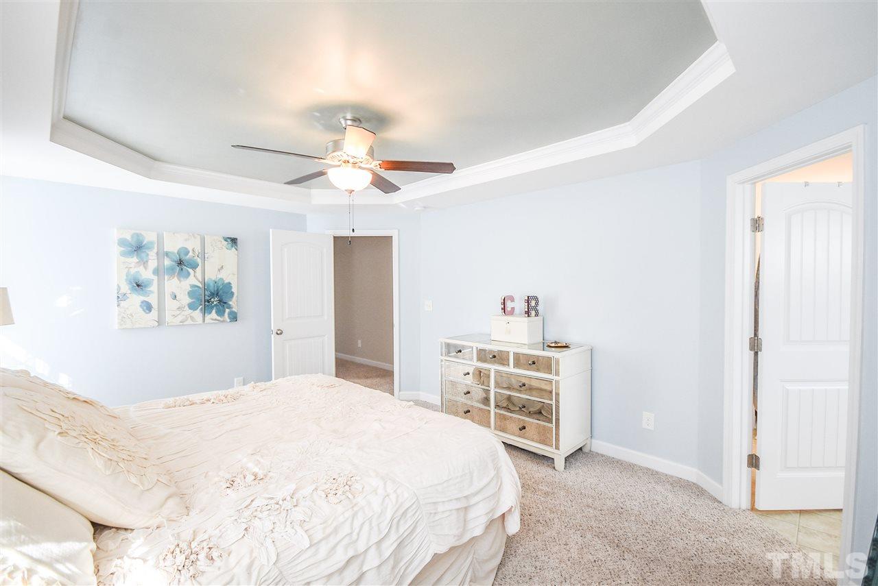 146 Shellbark Drive Spring Lake, NC 28390 - Photo 10 of 25 a spacious bedroom with a bed and a chandelier