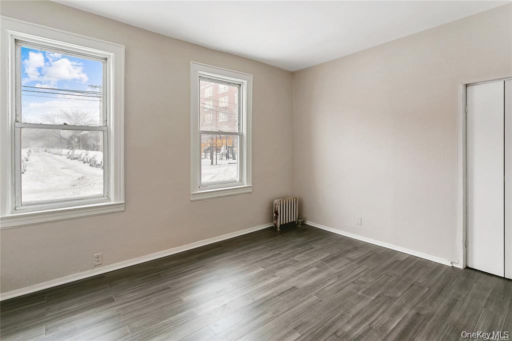 97-28 41st Avenue Queens, NY 11368 - Photo 7 of 29 an empty room with wooden floor and windows