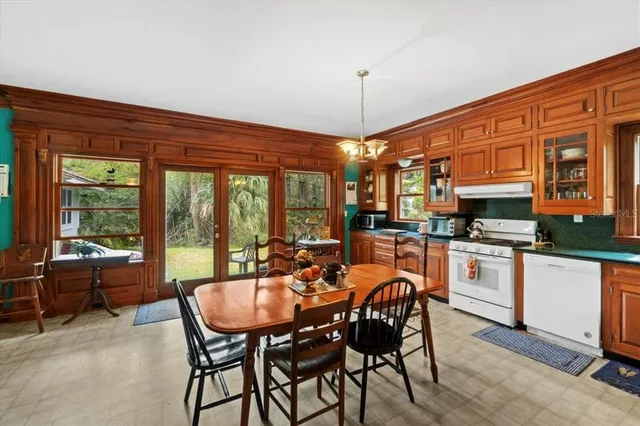 a dining room with furniture a chandelier and window
