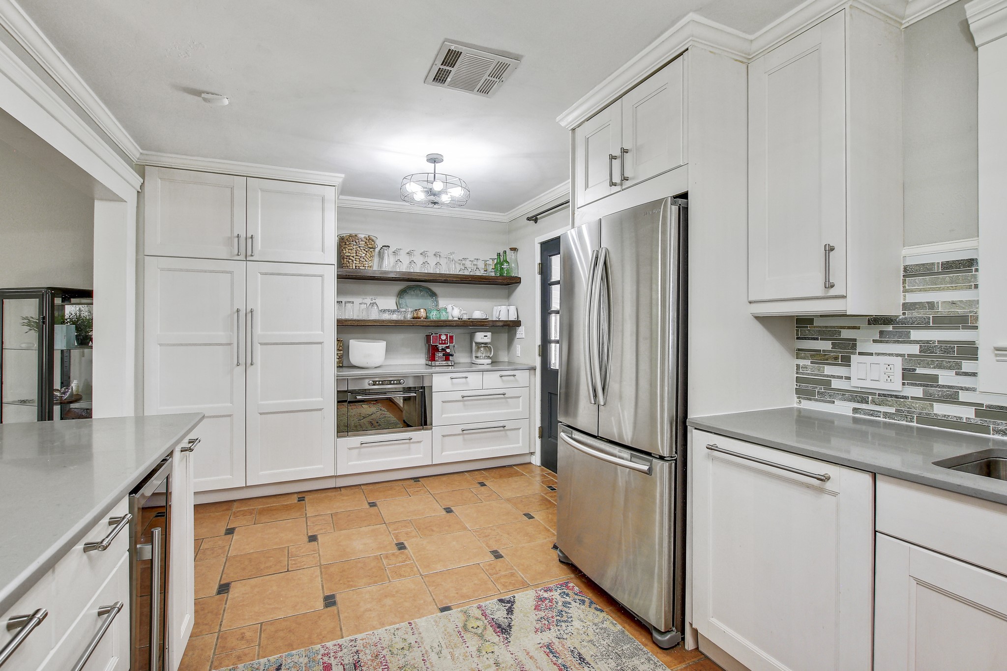 7741 Manassas Drive Austin, TX 78745 - Photo 16 of 39 Kitchen with white cabinetry, stainless steel appliances, open shelves, ornamental molding, and wine cooler