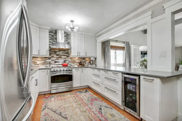 a bedroom with a bed a chair and potted plant on the dresser