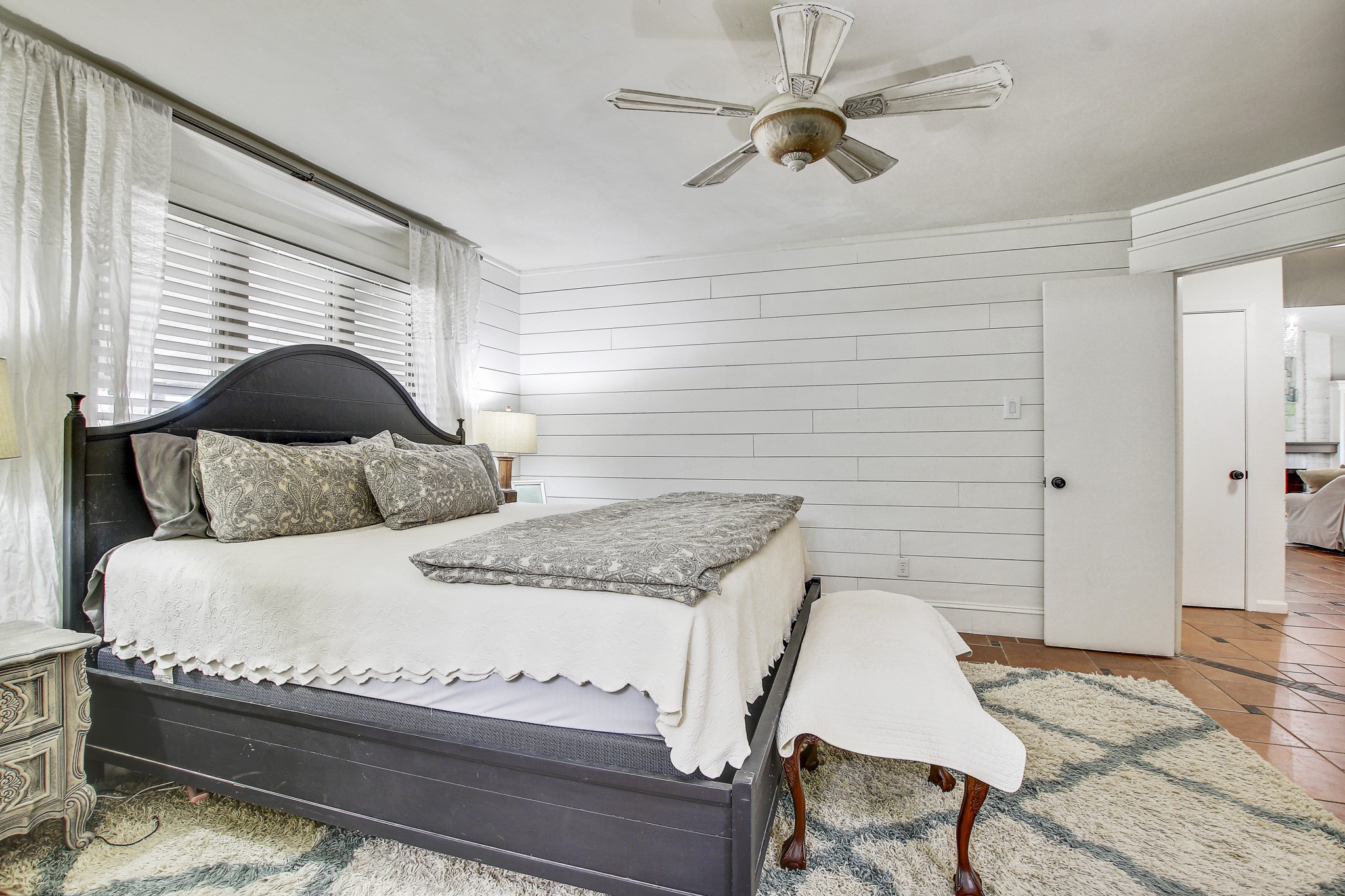 7741 Manassas Drive Austin, TX 78745 - Photo 20 of 39 Tiled bedroom featuring a ceiling fan and wood walls