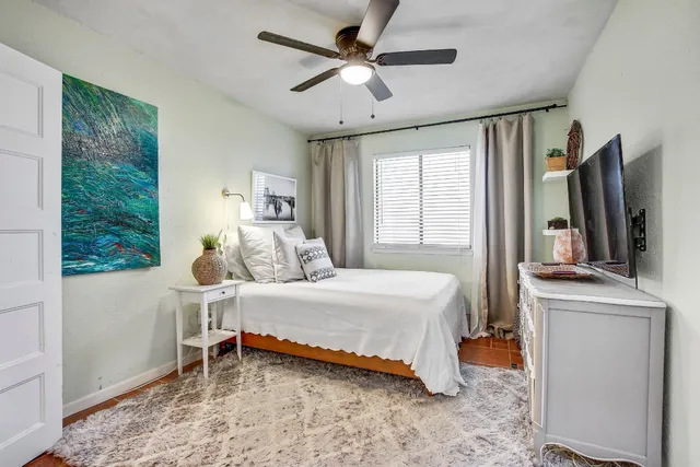 a bedroom with a bed and a large window