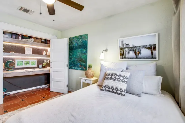 a view of a workspace with furniture and a window