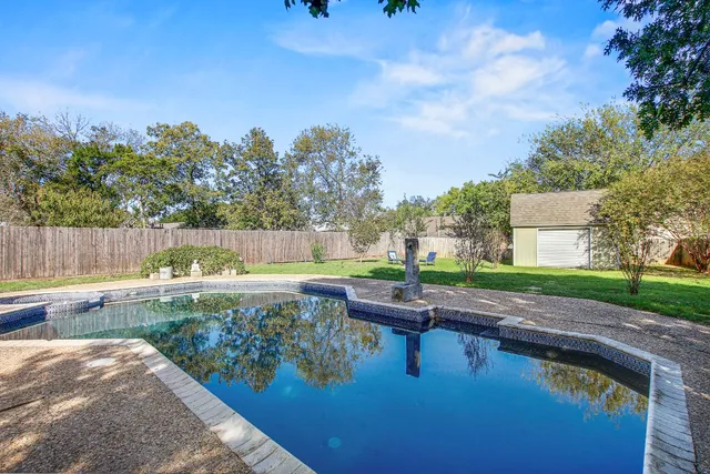a swimming pool with outdoor seating and yard