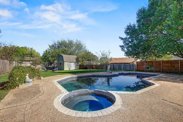 a view of a house with a yard chairs and table in the garden
