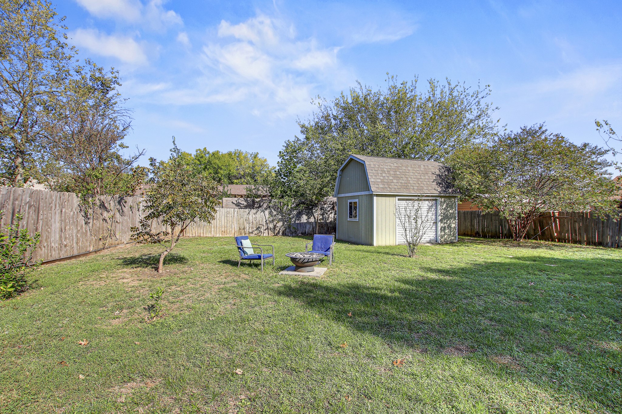 7741 Manassas Drive Austin, TX 78745 - Photo 34 of 39 Fenced backyard featuring an outdoor fire pit and a storage shed