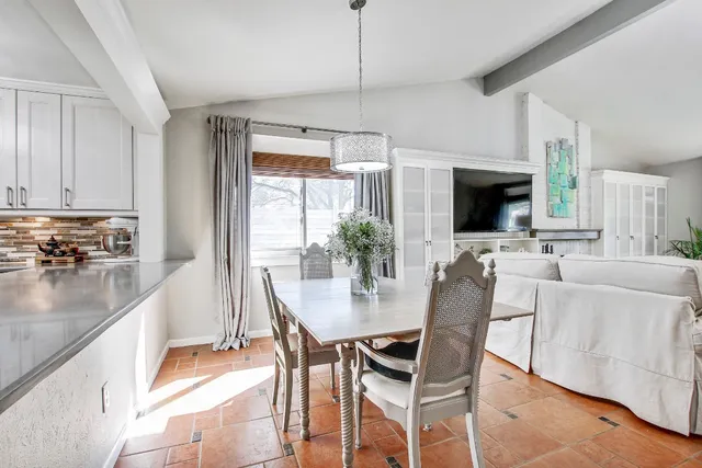 a dining room with furniture a chandelier and wooden floor