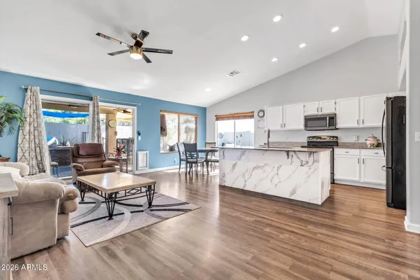 a living room with stainless steel appliances furniture and a view of kitchen