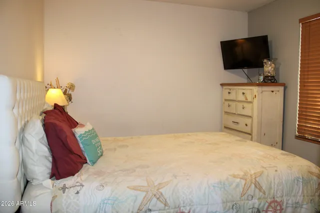 a bedroom with a bed and a flat screen tv