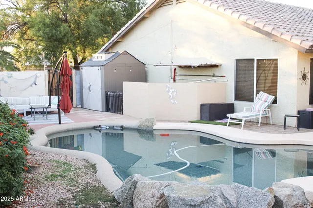 a patio with a table and chairs and potted plants